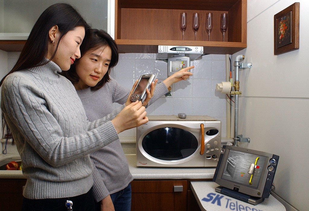 A household of Tower Palace is shown trying SK Telecom`s Home Network Service by controlling the electric home appliances through a cellular phone and PDA.